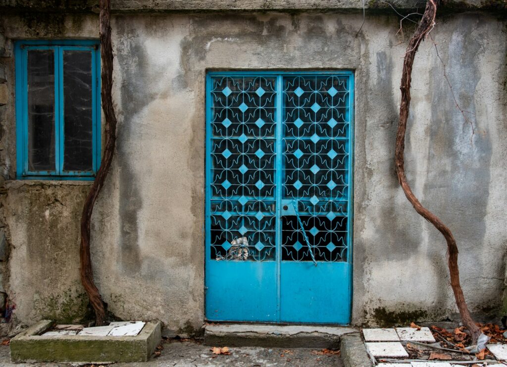 Closed metal blue vintage door. Traditional doors with decorations. House entrance.